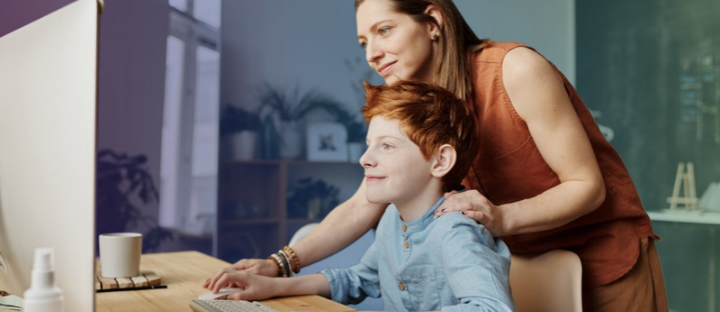 mother helping her child use a computer