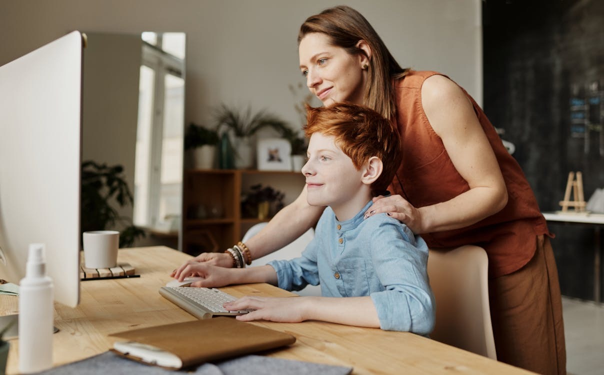 woman teaching son how to use computer safely