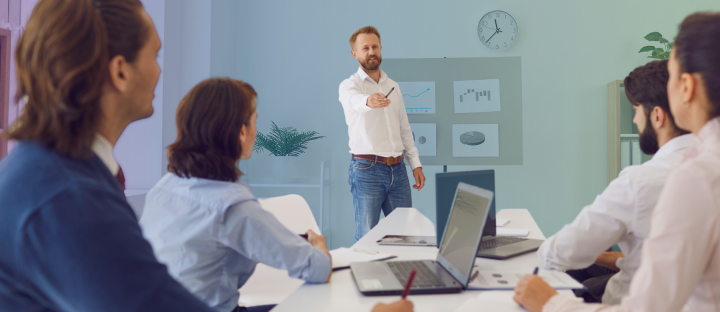male presenting course in front of group of professionals