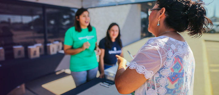 women at a booth conducting a public survey