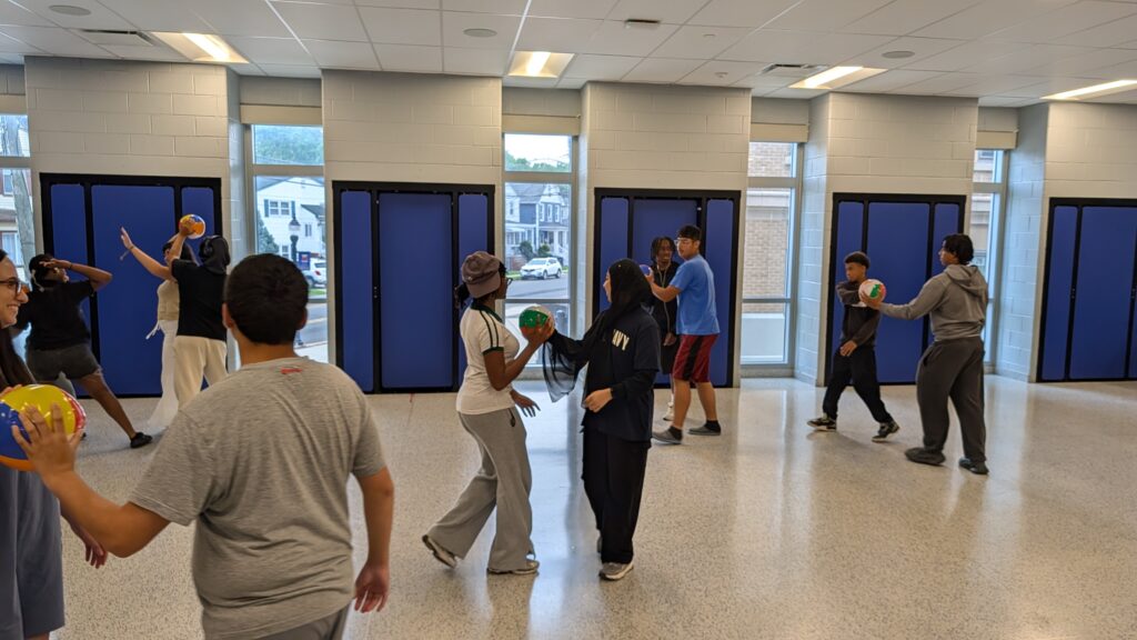 Pathways Summer Academy students participating in a team-building activity with beach balls