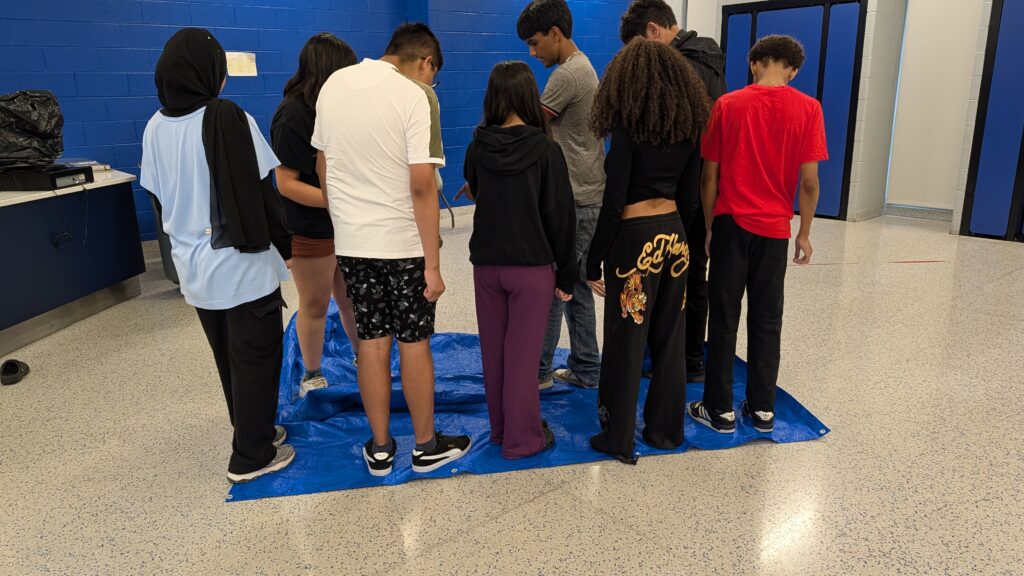 Pathways Summer Academy students working together during the Tarp Flip team-building activity