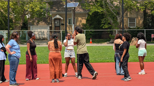 Students and mentors gathered on an outdoor track during a Pivotal Point boxing and wellness activity.