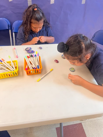 Two students work together on painted rock pets during the Pathways Summer Program.