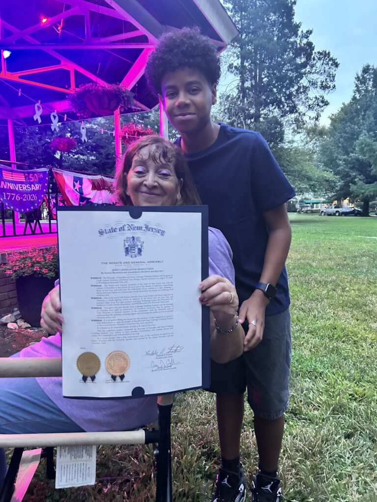 An adult and young person holding the New Jersey Joint Legislative Resolution during Dunellen’s Overdose Awareness Ceremony.
